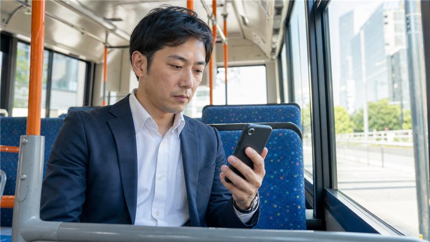 スマホで出会い系アプリを慎重に確認する男性